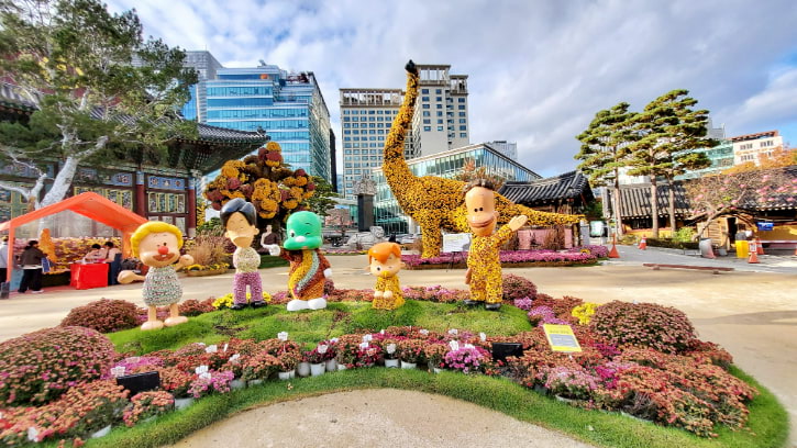 Colorful flower sculptures welcome visitors at Jogyesa Temple, a serene spot amidst the Seoul cityscape