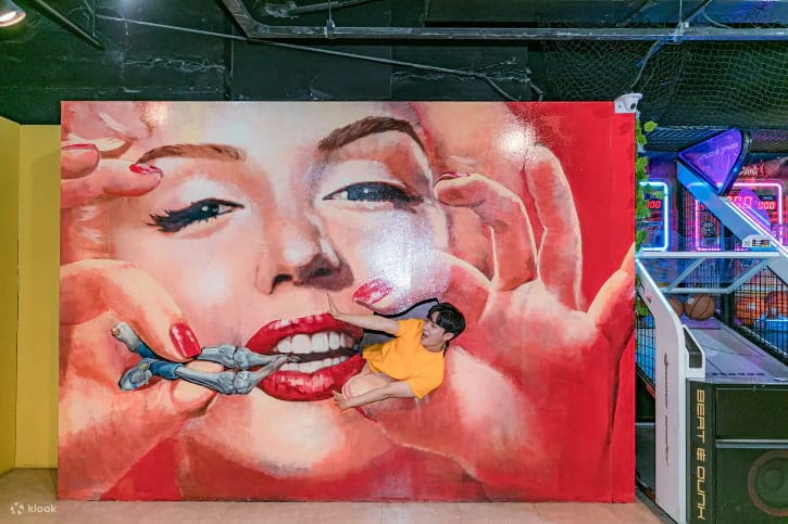 Interactive art at Alive Museum where a visitor appears held by a giant Marilyn Monroe mural