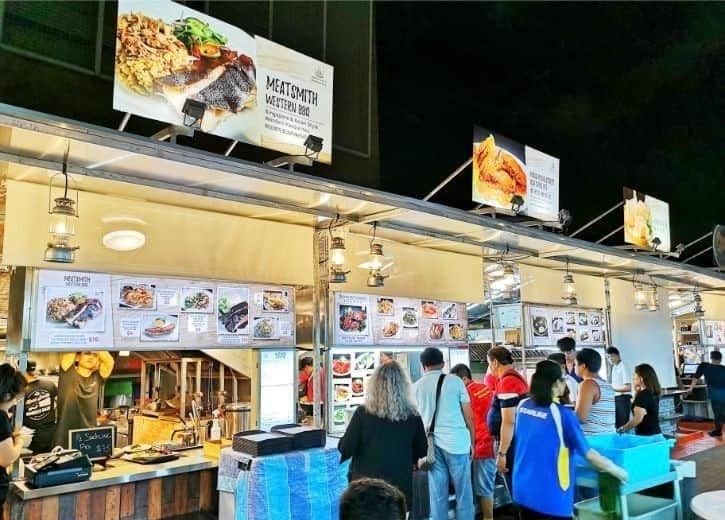 Colorful food stalls at Makansutra Gluttons Bay, offering Singaporean street food specialties