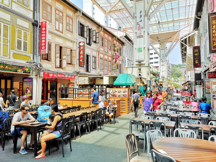 Chinatown Food Street, bustling with diners and flanked by colorful shophouses under a modern canopy