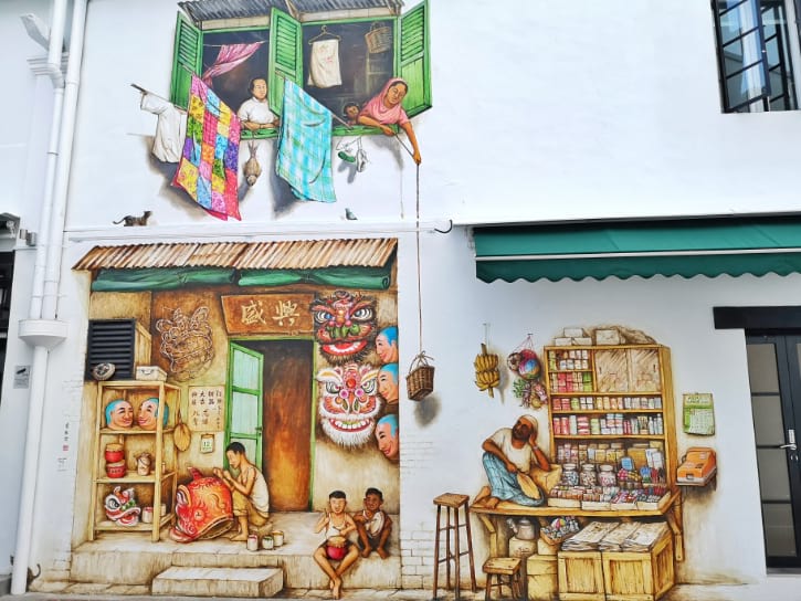 Vivid mural showing cultural scenes, mask-making, and a vintage shop on a building facade