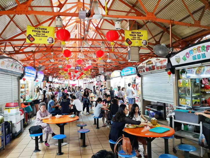 Maxwell Food Centre busy with people, red lanterns, and an orange roof above