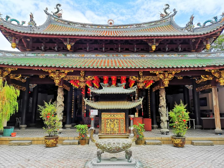 The Thian Hock Keng Temple, with its ornate traditional architecture and intricate carvings, under a bright sky