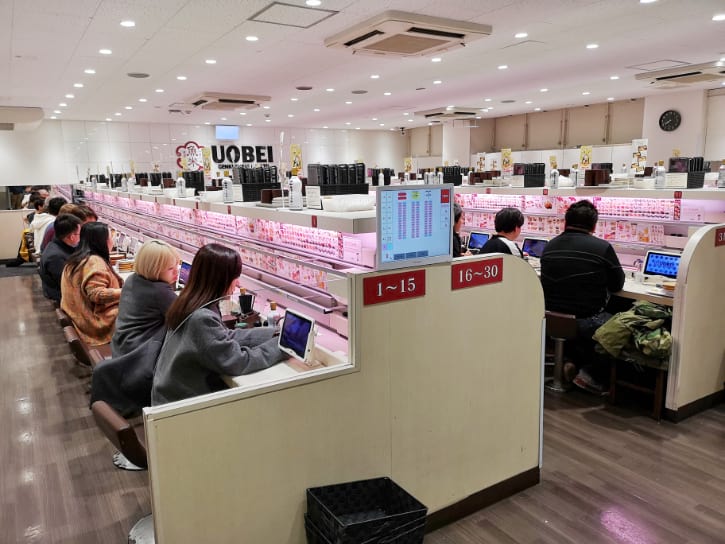 Uobei Shibuya Dogenzaka, featuring conveyor belt sushi in a lively, efficient dining setting