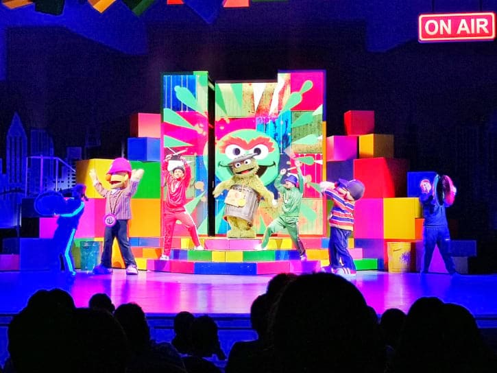 Colorful stage performance of Elmo's TV Time with Elmo and friends dancing