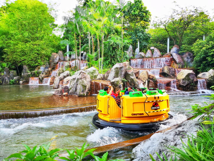 River raft ride amid animatronic dinosaurs and lush scenery