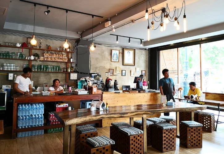 Interior of Baan Tha Tien Cafe in Bangkok, featuring traditional Thai decor and wooden furnishings