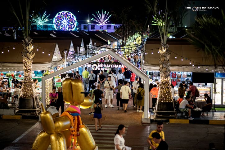 Vibrant night scene at The One Ratchada market in Bangkok, bustling with street vendors and visitors