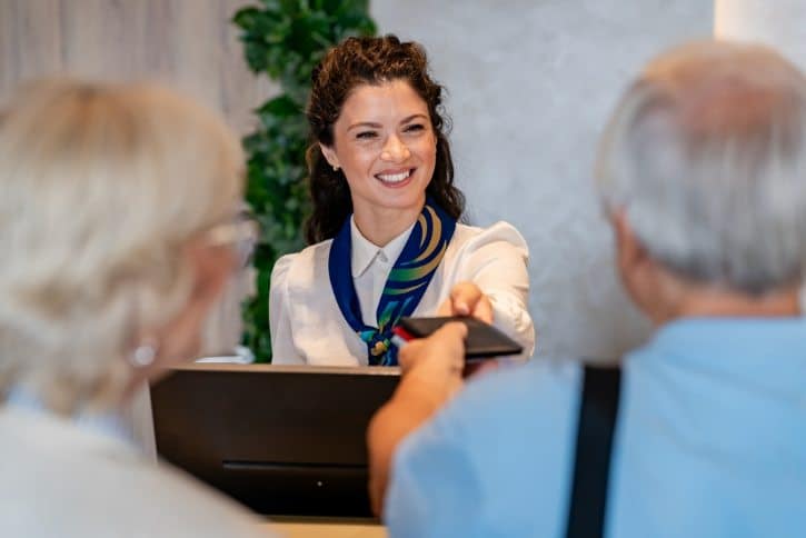 Hotel Reception Staff Assisting Guests At Check In
