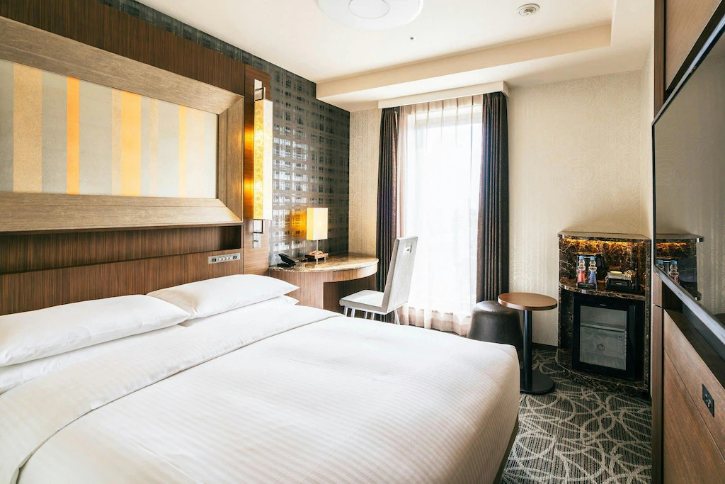 Hotel ro Richmond Hotel Premier Tokyo Scholeom with two large white beds, wood-paneled headboard, and bedside lamps by a desk near a bright window.
